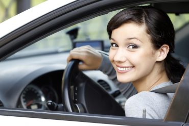 Uśmiechnięta kobieta w wynajętym samochodzie
