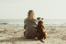 kobieta blondynka z psem na plaży