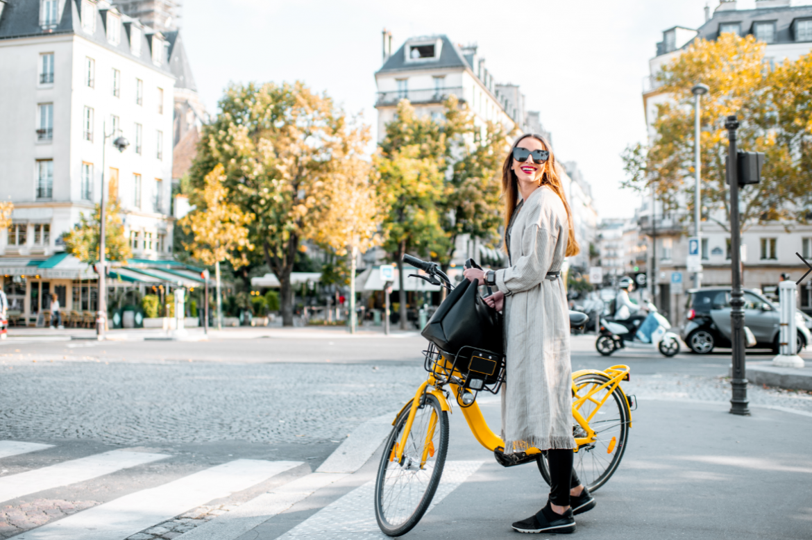 młoda elegancka kobieta na żółtym rowerze na ulicach Paryża