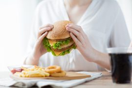 kobieta jedząca hamburgera